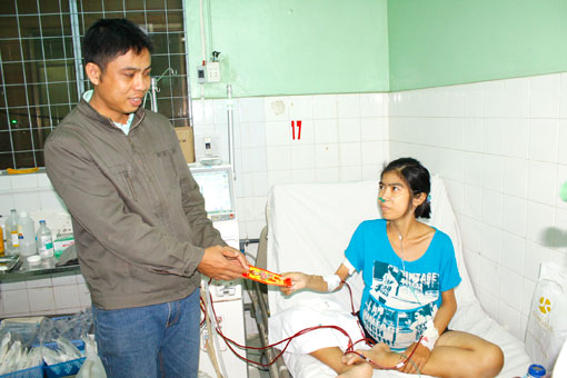 Một cán bộ của trường tặng tiền lì xì cho một bệnh nhân chạy thận nhân tạo tại Bệnh viện đa