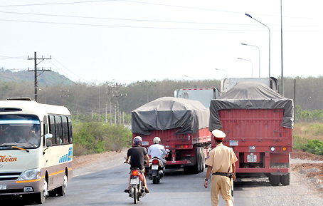 Hai chiếc xe chở bauxite di chuyển cùng lúc qua cầu La Ngà bị tổ cảnh sát giao thông chặn lại kiểm tra.