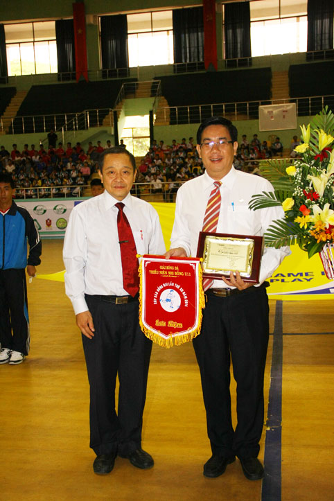 Tổng biên tập báo Đồng Nai Trần Huy Thanh (trái) trao hoa và thư cám ơn cho đại diện nhà tài trợ chính