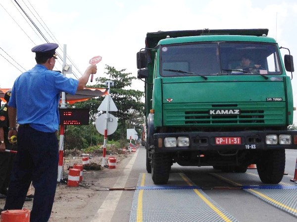 Lực lượng chức năng tiến hành kiểm soát tải trọng phương tiện trên tuyến Quốc lộ. (Ảnh: TTXVN)