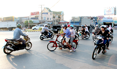 Bốn xe máy đi ngược chiều lao thẳng ra đường, trong khi nhiều xe ô tô, xe máy đi qua vòng xoay Tam Hiệp.