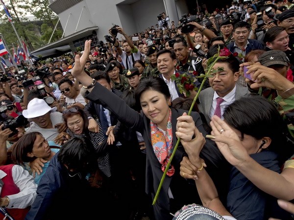 Thủ tướng Thái Lan Yingluck Shinawatra (giữa) vẫy chào người ủng hộ ở ngoại ô Bangkok ngày 7/5. (Ảnh: AFP/TTXVN)