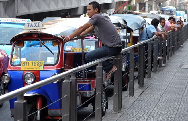 Lái xe tuk-tuk Thái Lan đợi khách hàng tại trung tâm thương mại ở thủ đô Bangkok. (Ảnh: AFP/TTXVN)