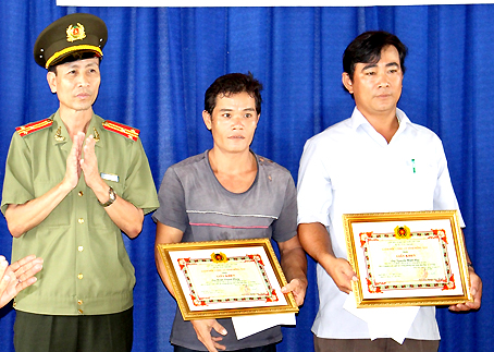 Đại diện Công an tỉnh trao giấy khen cho 2 anh Nguyễn Minh Huy và Đoàn Thanh Hùng có thành tích truy bắt tội phạm.
