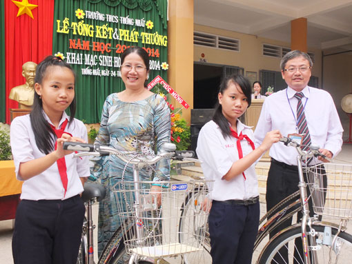 Thầy Nguyễn Huy Nguyên (bìa trái) cùng đại diện lãnh đạo địa phương tặng xe đạp cho học sinh giỏi có hoàn cảnh khó khăn.