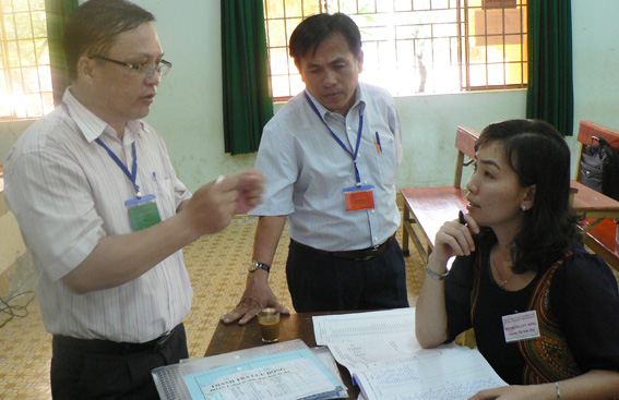 Bà Trương Thị Kim Huệ, Phó giám đốc Sở GD-ĐT (bên trái) nghe các thành viên trong Hội đồng thi Trường THPT Bình Sơn báo cáo việc thực hiện trong ngày thi đầu tiên. 