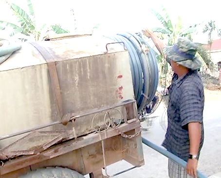 Ông Nguyễn Minh Khánh cuộn lại các ống nước sau một ngày dài chở nước đi bán.