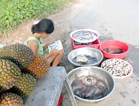 Những ngày hè, bé Nguyệt (lớp 5, ấp 1, xã Thạnh Phú, huyện Vĩnh Cửu) bán hàng phụ cha mẹ.
