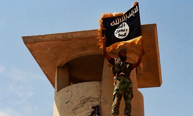 Một chiến binh IS cầm lá cờ Nhà nước Hồi giáo tự xưng ở Salahuddin, Iraq (Nguồn: AFP)