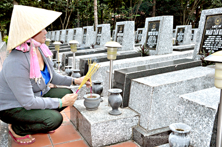 Bà Phạm Thị Em chăm sóc các phần mộ tại Nghĩa trang liệt sĩ huyện Long Thành.