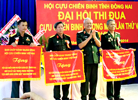 Trung tướng Lê Thành Tâm, Phó chủ tịch Hội Cựu chiến binh Việt Nam, trao cờ thi đua cho Hội Cựu chiến binh các huyện Long Thành, Trảng Bom, Xuân Lộc và Cục Hải quan Đồng Nai. Ảnh: T.Toàn