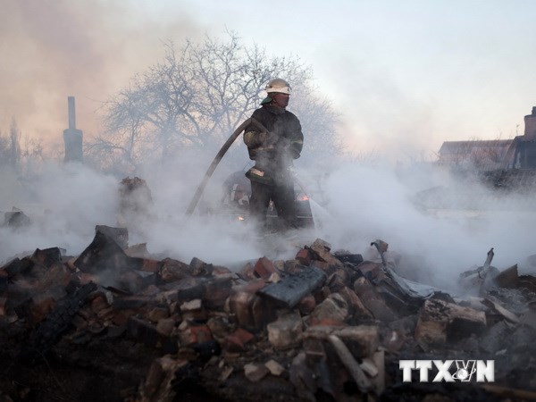  Nhân viên cứu hỏa dập các đám cháy tại một số ngôi nhà bị phá hủy do trúng đạn pháo tại quận Kuibishevskiy, gần sân bay ở Donetsk, miền đông Ukraine ngày 20/11. (Nguồn: AFP/TTXVN)