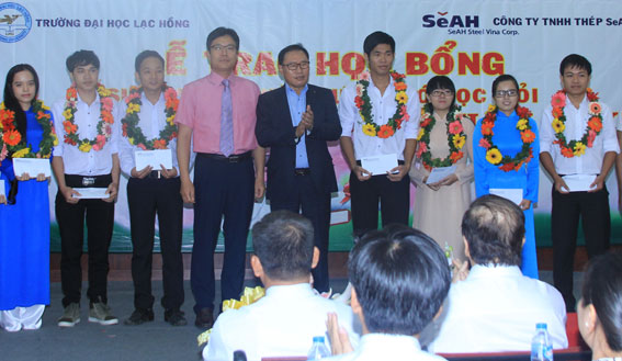 Ông Nam Hyung Kun (đứng giữa) Tổng giám đốc Công ty TNHH thép SeAh trao học bổng cho các sinh viên.