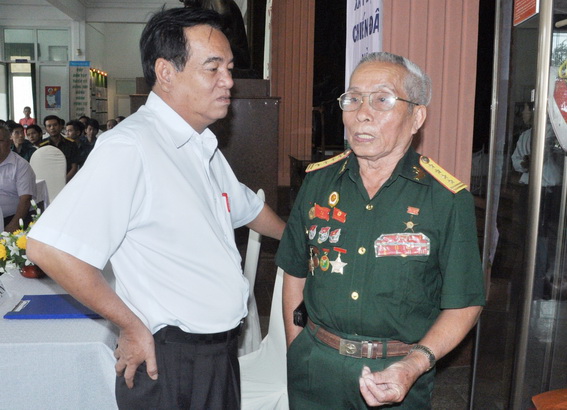 Đồng chí Trần Đình Thành, Bí thư Tỉnh ủy trao đổi với Đại tá - Anh hùng lực lượng vũ trang nhân dân Lê Duy Chín.