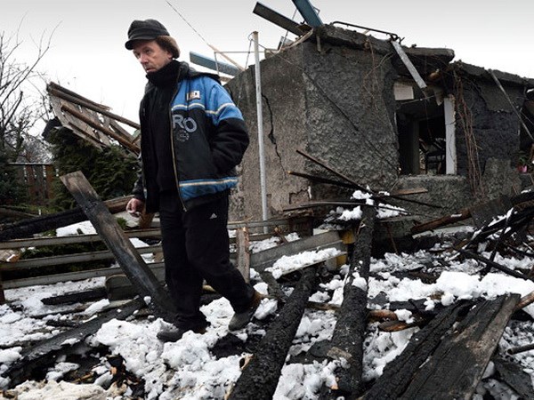 Một người đàn ông đứng bên cạnh nhà của mình bị phá hủy ở huyện Kuibishevskiy, Donetsk, miền đông Ukraine ngày 9/12 vừa qua. (Nguồn: AFP).