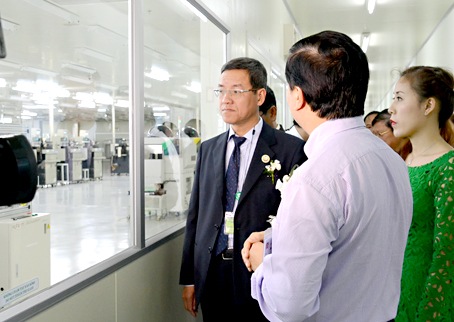 Chủ tịch UBND tỉnh Đinh Quốc Thái (bìa trái) đang tham quan dây chuyền sản xuất mạch tích hợp và các linh kiện bán dẫn dùng cho xe hơi của Công ty On Semiconductor Việt Nam (Mỹ) tại Khu công nghiệp Biên Hòa 2. Ảnh: K.Giới