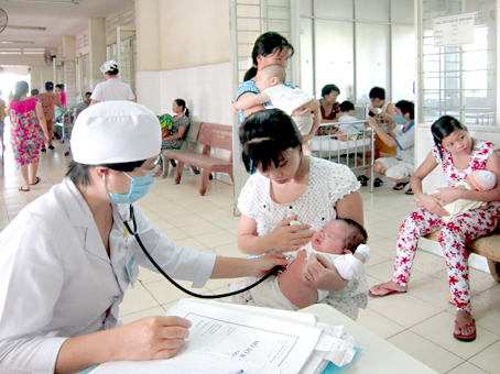 Bác sĩ Phạm Thị Thu Thủy khám bệnh cho trẻ bị viêm phổi tại Bệnh viện nhi đồng Đồng Nai.  Ảnh: A.AN