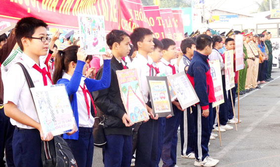 Học sinh với biểu ngữ, tranh cổ động tham gia lễ ra quân năm ATGT ở thành phố Biên Hòa