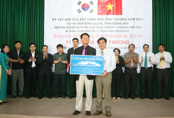 đại diện ACEF (bên trái) trao tượng trưng số tiền 1,632 tỷ đồng xây dựng nhà tình thương cho UBND huyện Định Quán
