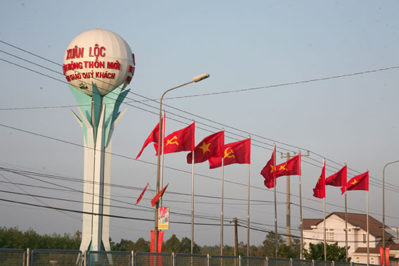 Cờ Đảng, cờ Tổ quốc và biểu ngữ được trang trí dọc theo quốc lộ 1A.