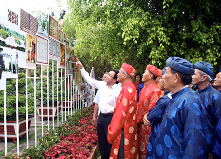 Các đại biểu tham quan triển lãm “300 năm Văn miếu Trấn Biên - Nơi tôn vinh giá trị học” vào sáng 20-3-2015.