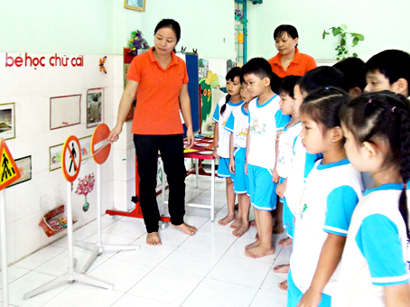 Trẻ em ở một trường mầm non huyện Long Thành tìm hiểu về Luật Giao thông đường bộ.  Ảnh: VĂN VIỆN