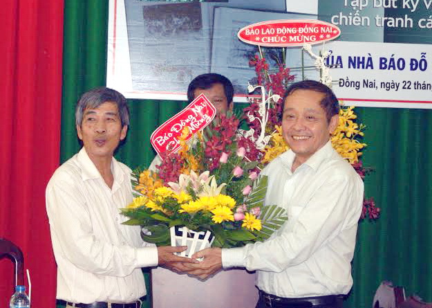  Đồng chí Trần Huy Thanh, Phó tổng biên tập Báo Đồng Nai tặng hoa chúc mừng đồng chí Đỗ Trung Tiến