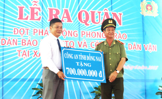  Đại diện Công an tỉnh tặng số tiền tượng trưng cho đại diện huyện Định Quán.