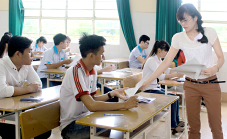 Giám thị phát giấy thi môn Toán cho thí sinh tại điểm thi Trường TH - THCS - THPT Đinh Tiên Hoàng.