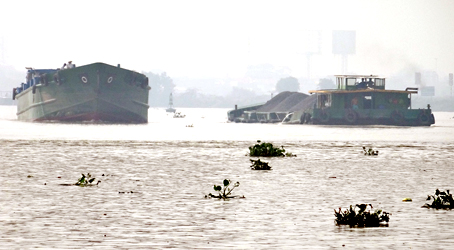 Sà lan chở quá tải (phải) và sà lan không tải đang lưu thông trên sông Đồng Nai.