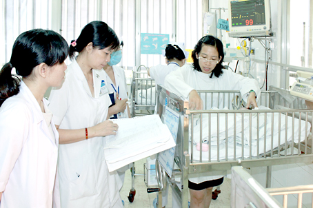 Bác sĩ Nguyễn Thị Kim Nhi, Bệnh viện nhi đồng 2 TP. Hồ Chí Minh (bìa phải) kiểm tra tại khoa hồi sức sơ sinh.