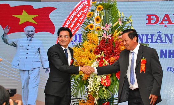 Phó chủ tịch UBND tỉnh Võ Văn Chánh (trái) thay mặt lãnh đạo tỉnh tặng hoa cho Đại hội