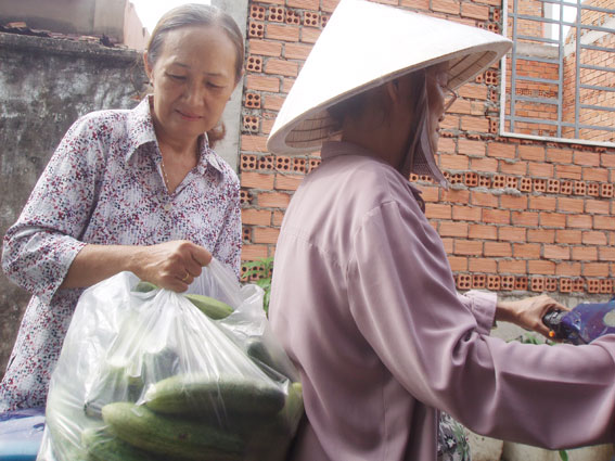 Bà Huỳnh Thị Lộc (trái) đang trên đường đi chợ về để nấu những phần cơm, bún xào phát miễn phí cho bệnh nhân, người cơ nhỡ.  Ảnh: Đ.Phú