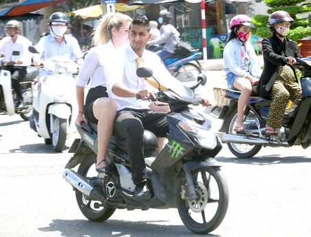 Hai giáo viên (người nước ngoài) dạy ở một trường thuộc TP.Biên Hòa không chấp hành đội mũ bảo hiểm khi đi xe máy trên đường.
