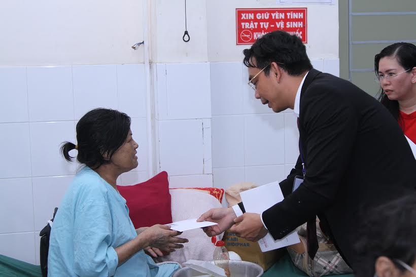 Đại diện Công ty TNHH bảo hiểm nhân thọ Prudential Việt Nam tặng quà cho bệnh nhân nghèo