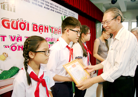 Ban tổ chức trao giải cho em Trần Minh Nguyên (Trường THCS Nguyễn Bỉnh Khiêm, TP.Biên Hòa) đạt giải nhất khối THCS.