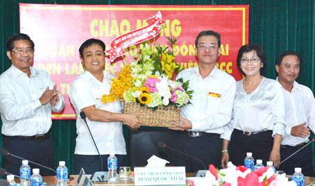 Chairman Dinh Quoc Thai presents flowers to Taxation Department’s representative