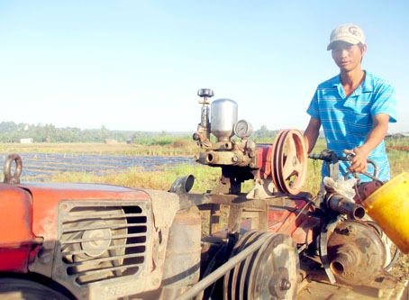 Anh Phạm Xuân Tấn (con trai thứ của ông Bắc) với chiếc máy xới đã góp phần biến ruộng đá thành đất ruộng màu mỡ.