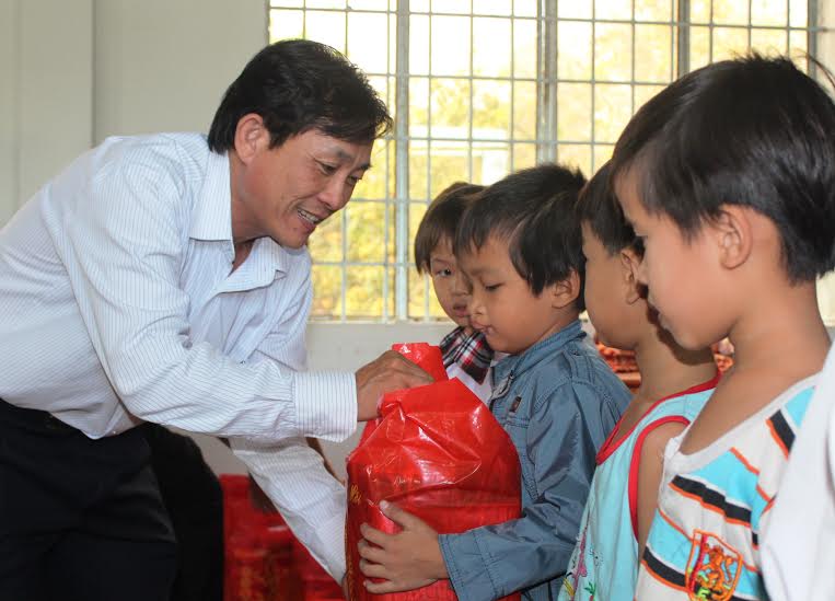 Ông Hoàng Văn Long, Quyền giám đốc Qũy Bảo trợ trẻ em tỉnh tặng quà cho trẻ em có hoàn cảnh khó khăn tại huyện Long Thành