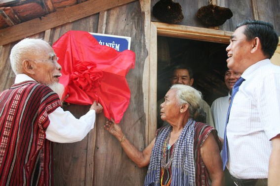 Vợ chồng Già làng Năm Nổi thực hiện nghi thức mở cửa Nhà lưu niệm với sự chứng kiến của Chủ tịch UBMTTQ tỉnh Huỳnh Văn Tới (bên phải)