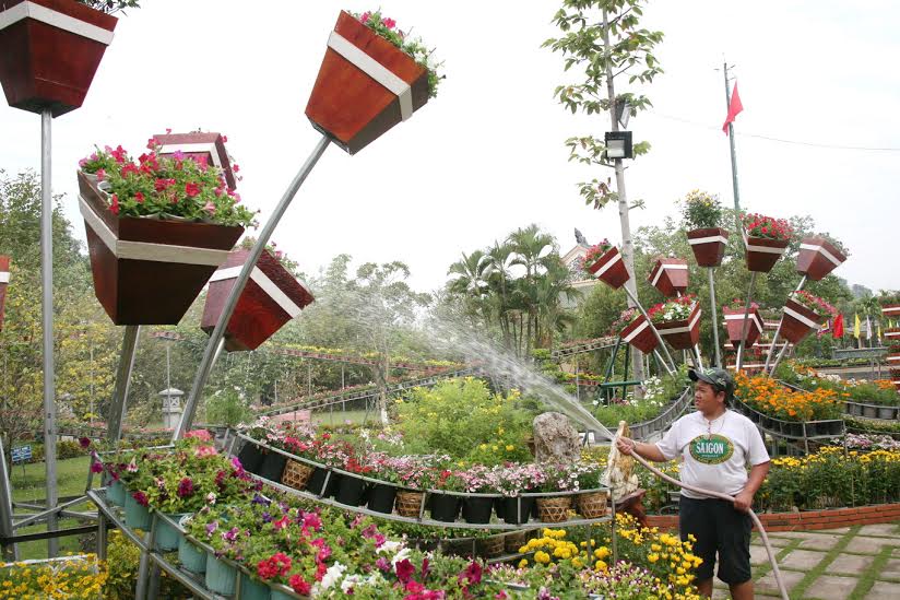 công nhân đang tưới nước cho hoa tại một phối cảnh ở đường hoa Trấn Biên xuân Bính Thân 2016