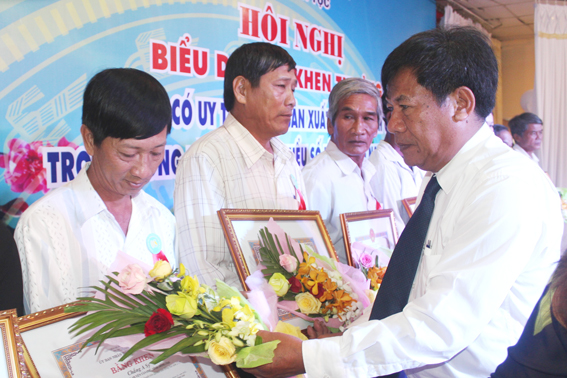  Đồng chí Điểu Bảo, Trưởng ban Dân tộc tỉnh tặng hoa cho các hộ sản xuất kinh doanh giỏi trong đồng bào dân tộc thiểu số năm 2015