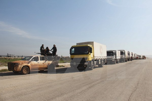 Đoàn xe tải chở hàng cứu trợ tới thị trấn Fuaa và Kafraya, tỉnh Idlib, Tây Bắc Syria. (Nguồn: AFP/TTXVN)