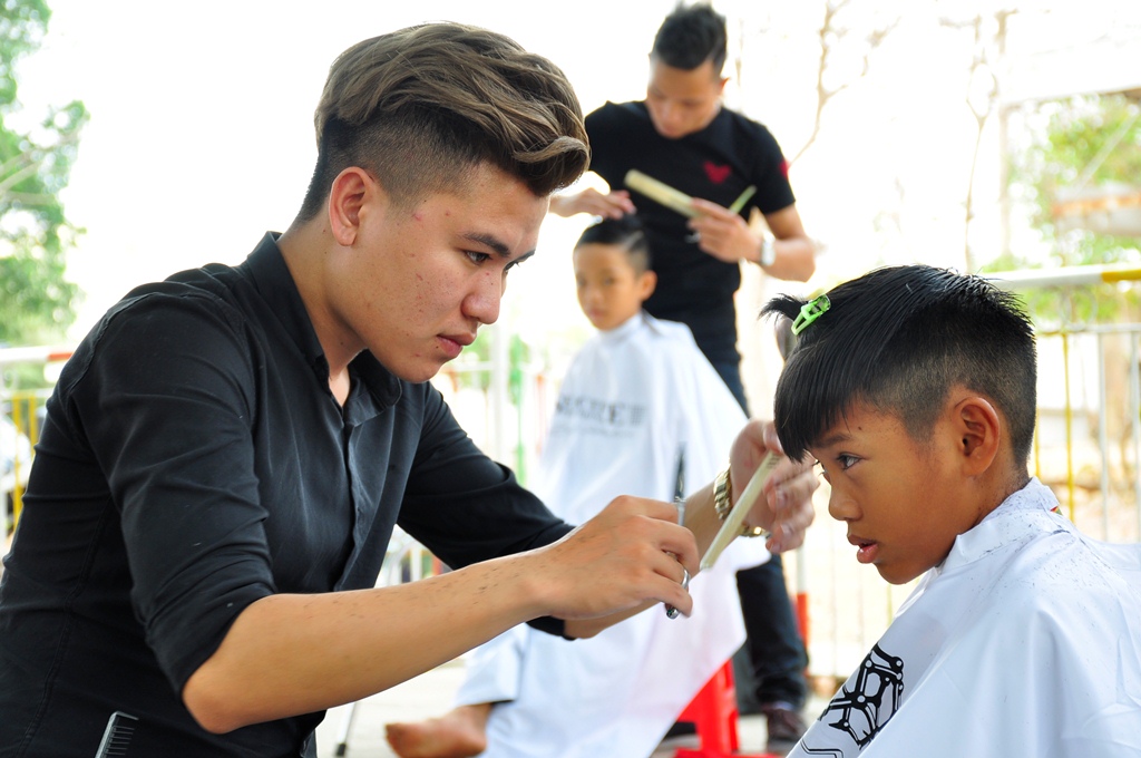  Các thợ lành nghề của Tiêm hớt tóc Idol cắt tóc miễn phí cho các em học viên tại Trung tâm bảo trợ huấn nghệ cô nhi Biên Hòa
