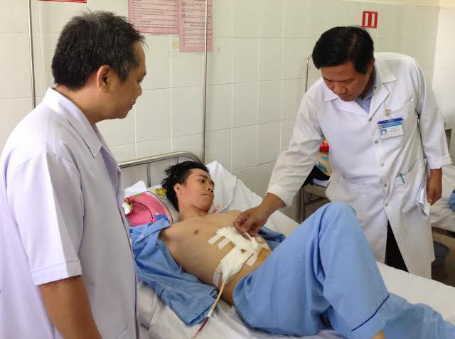 Bác sĩ CK.II Hồ Thanh Phong (bìa trái) cùng đồng nghiệp tại Bệnh viện đa khoa khu vực Long Thành kiểm tra vết mổ cho bệnh nhân Cường.