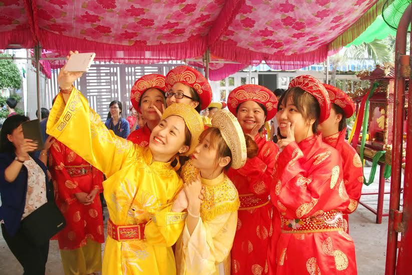 các thiếu nữ trong trang phục truyền thống chụp hình lưu niệm sau khi việc dâng lễ vật lên Vua Hùng hoàn tất