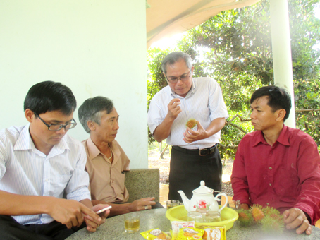 Trưởng ban Tuyên giáo TX.Long Khánh Phạm Văn Hoàng (đứng) trao đổi với nông dân về việc xây dựng thương hiệu chôm chôm chín sớm vùng đất Bàu Sầm.