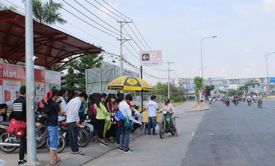 Người dân chờ đón xe khách trên xa lộ Hà Nội sáng 30-4.
