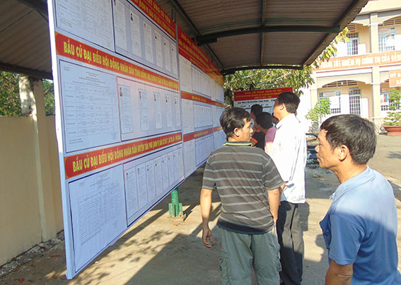 Người dân xã Trà Cổ, huyện Tân Phú xem danh sách người ứng cử Đại biểu Quốc hội khóa XIV và đại biểu HĐND các cấp nhiệm kỳ 2016-2021 được dán tại trụ sở UBND xã. (ảnh: Ban Tuyên giáo Huyện ủy Tân Phú cung cấp).