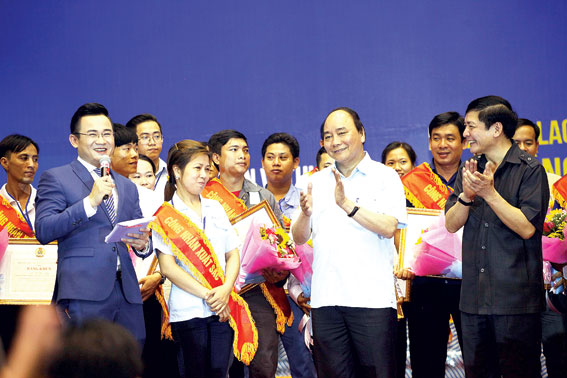 Thủ tướng Chính phủ Nguyễn Xuân Phúc và Chủ tịch Tổng Liên đoàn lao động Việt Nam Bùi Văn Cường (áo đen) tại buổi gặp gỡ các công nhân lao động.